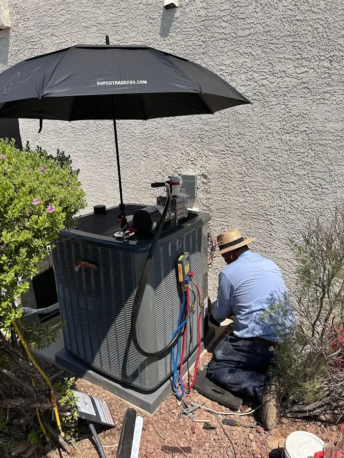 HVAC technician performing outdoor AC maintenance in Sanger